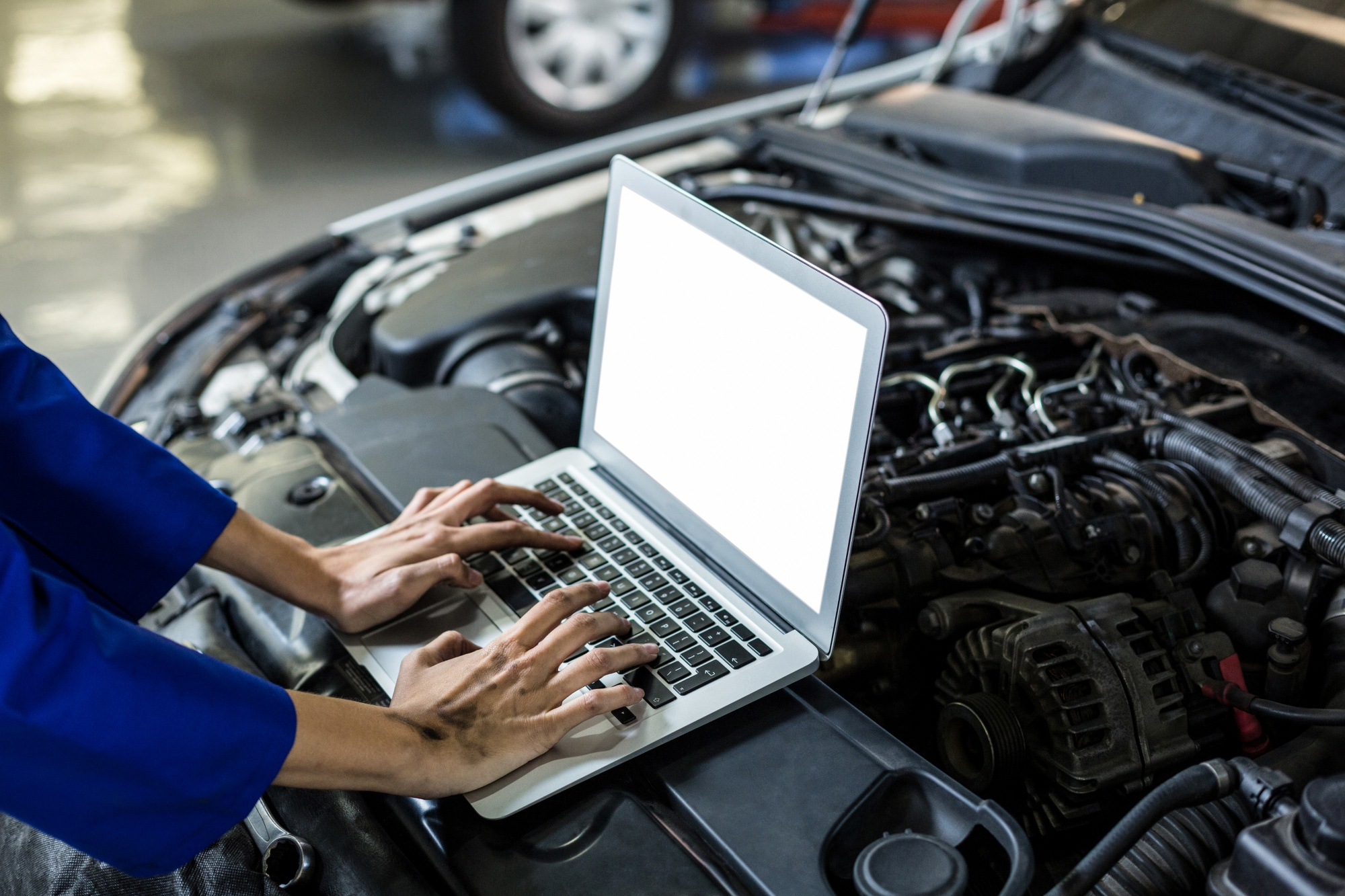 Technician using a laptop to conduct vehicle inspection