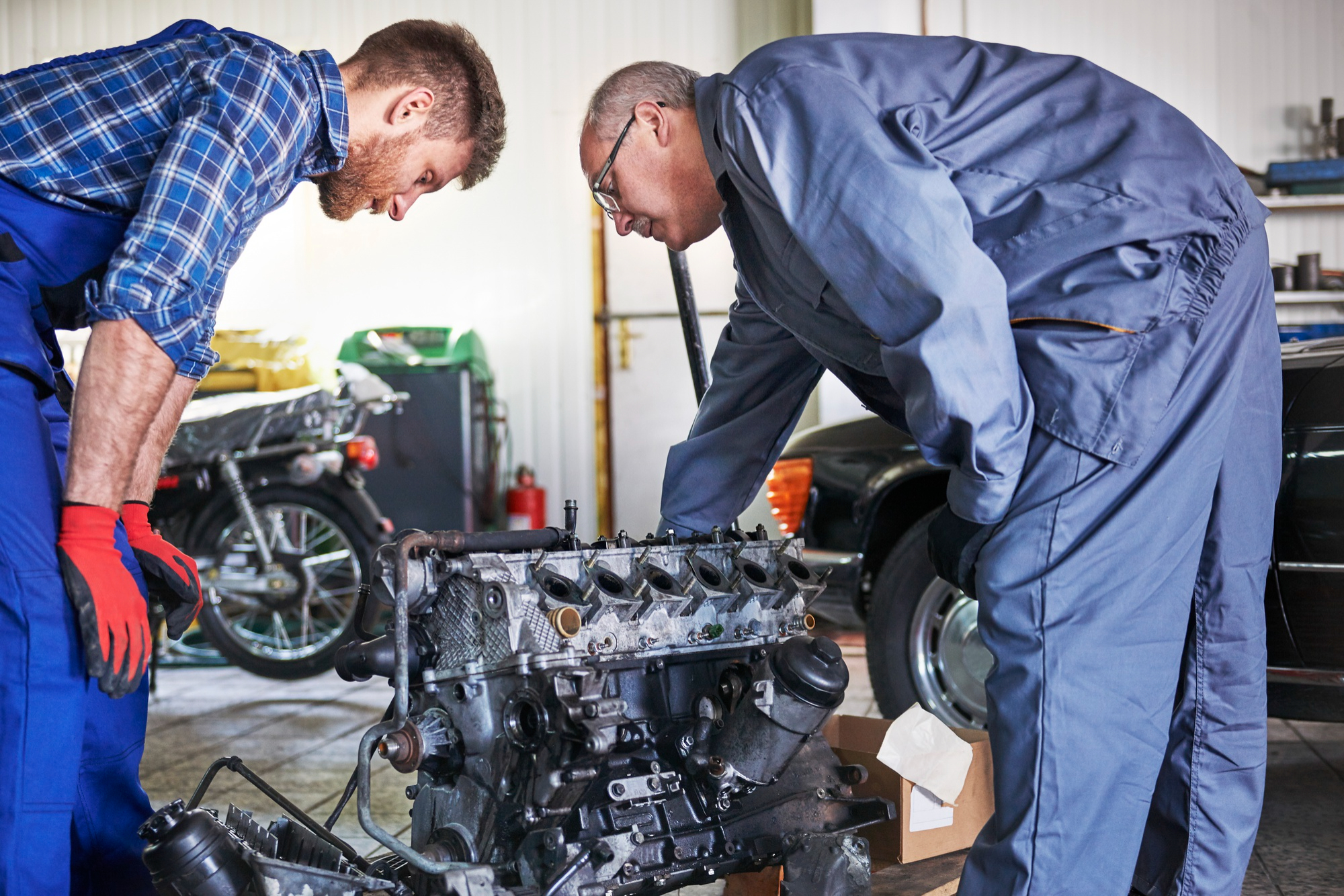 Expert mechanics examining engine for faults